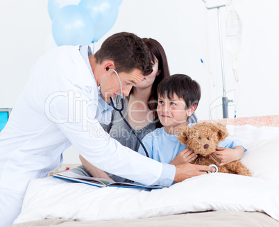 Attentive doctor playing with a little boy and his mother