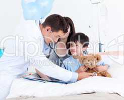 Attentive doctor playing with a little boy and his mother