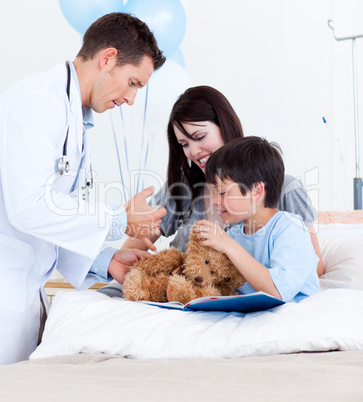 Attractive doctor playing with a little boy and his mother