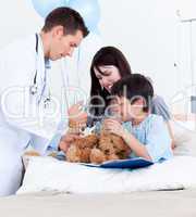 Attractive doctor playing with a little boy and his mother