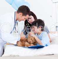 Caucasian doctor playing with a little boy and his mother