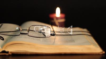 book, glasses and candle.