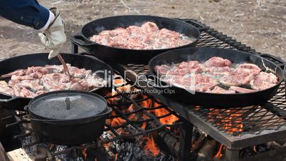 Lamb chops turned over open fire
