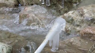 Icicle against a mountain stream