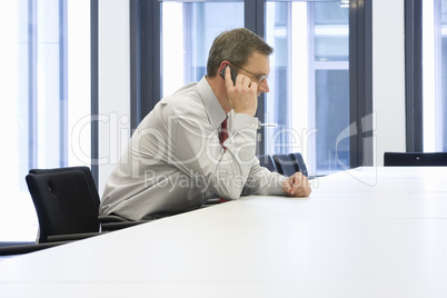 Manager telefoniert in Konferenzraum