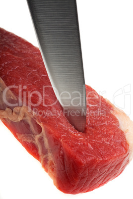 Küchenmesser schneidet durch ein rohes Steak