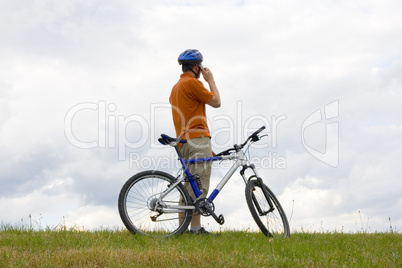 Mann mit Fahrrad telefoniert