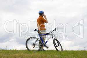 Mann mit Fahrrad telefoniert