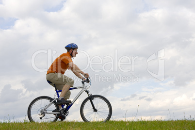 Mountainbiker fährt auf einer Wiese