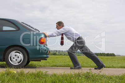 Geschäftsmann schiebt Auto