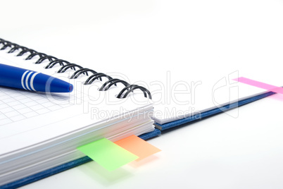 open notebook with blue pen and color bookmarks