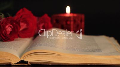 book, candle and red roses.