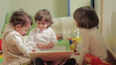 three little girls using laptop computer