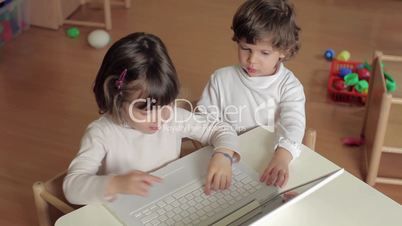 two little girls using laptop computer