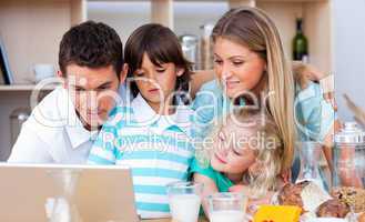 Lovely family using laptop during the breakfast