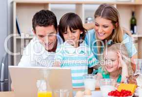 Jolly family using laptop during the breakfast