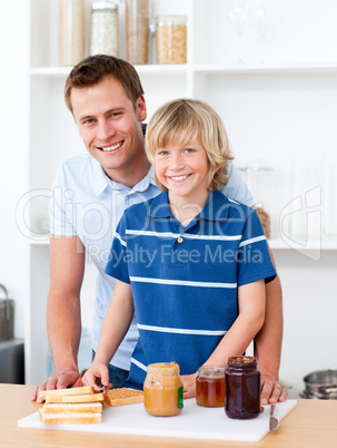 Smiling father helping his son prepare the breakfast