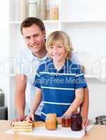 Smiling father helping his son prepare the breakfast