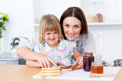 Attentive mother helping her daughter prepare the breakfast