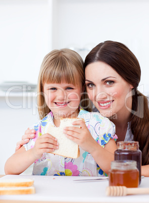 Charming mother and her daughter having breakfast