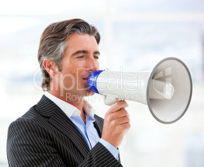 Confident businessman yelling through a megaphone