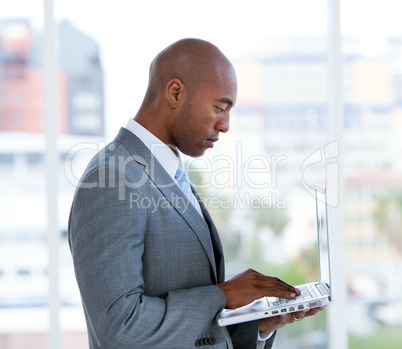 Portrait of an assertive businessman working at a laptop