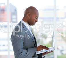 Portrait of an assertive businessman working at a laptop