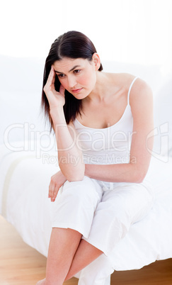 Portrait of a unhappy woman sitting on bed