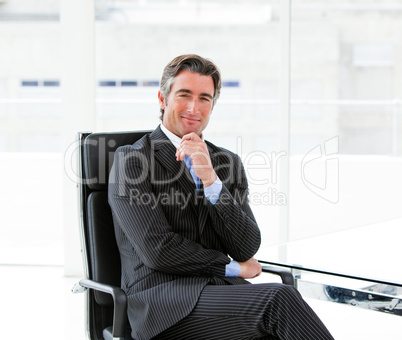 Charming male executive sitting in his office
