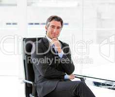 Charming male executive sitting in his office