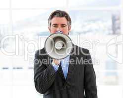 Mature businessman yelling through a megaphone