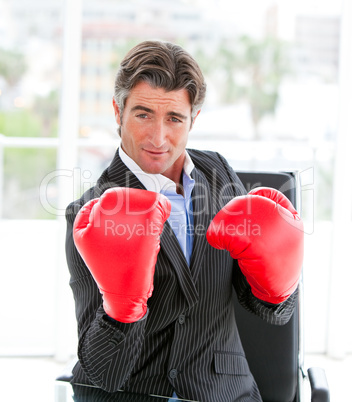 Self-assured businessman wearing boxing gloves