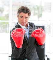 Self-assured businessman wearing boxing gloves