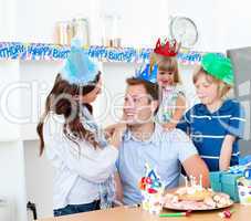 Elated man celebrating his birthday with his wife and his childr