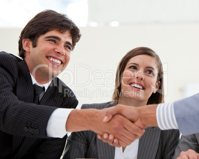 Smiling businessman and his colleague closing a deal with a part