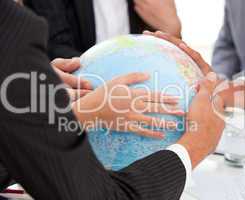 Close-up of a serious businessteam touching terrestrial globe