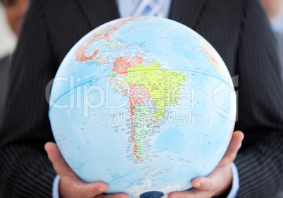 Close-up of an executive holding a terrestrial globe