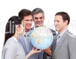 Positive businessteam looking at a terrestrial globe