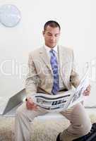 Confident manager reading a newspaper