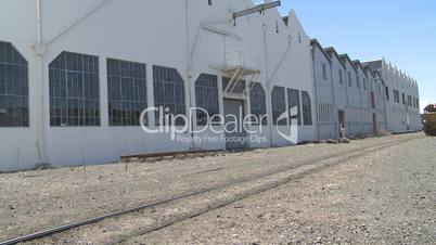 Train and containers pass industrial sheds