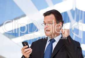 Businessman Looking at Cell Phone Clinches His Fist in Joy
