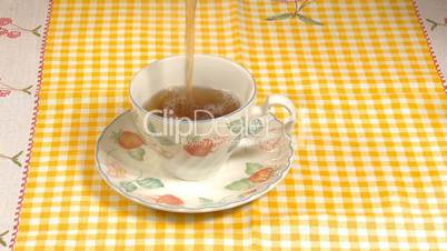 Pouring hot tea on cup