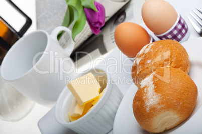 Eier, Brötchen, Butter und Kaffee auf weißem Hintergrund