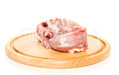 Uncooked pork meat on round hardboard