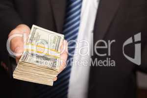 Businessman Handing Over Stack of Cash