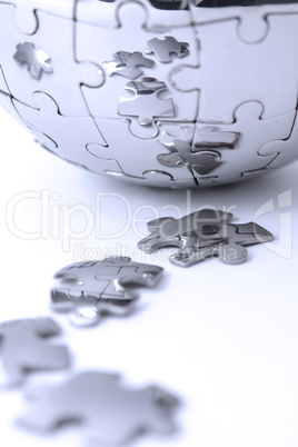 Metal puzzle globe isolated on white background, close-up in blue light