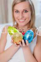 Happy woman showing colorful easter eggs