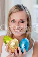 Delighted woman showing colorful easter eggs