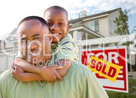 Father and Son In Front of Real Estate Sign and Home