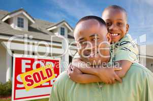 Father with Son In Front of Real Estate Sign and Home